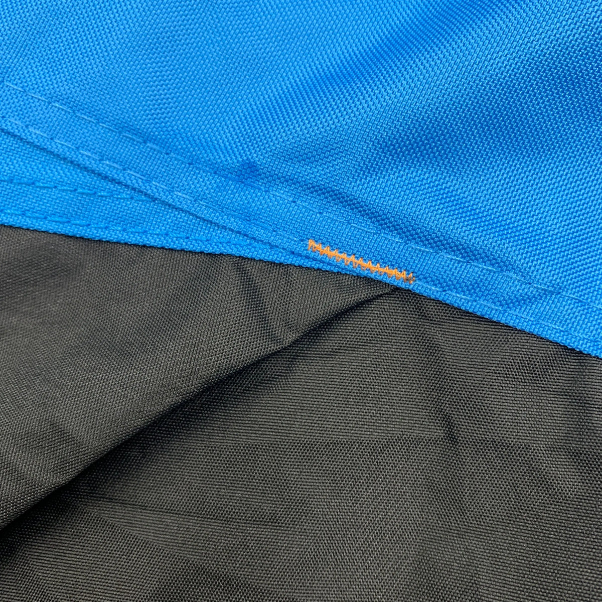 Close-up of black and blue reinforced corners on a vehicle cover, designed to improve durability, prevent wear and tearing, provide extra strength for protection against abrasion, and extend cover lifespan.