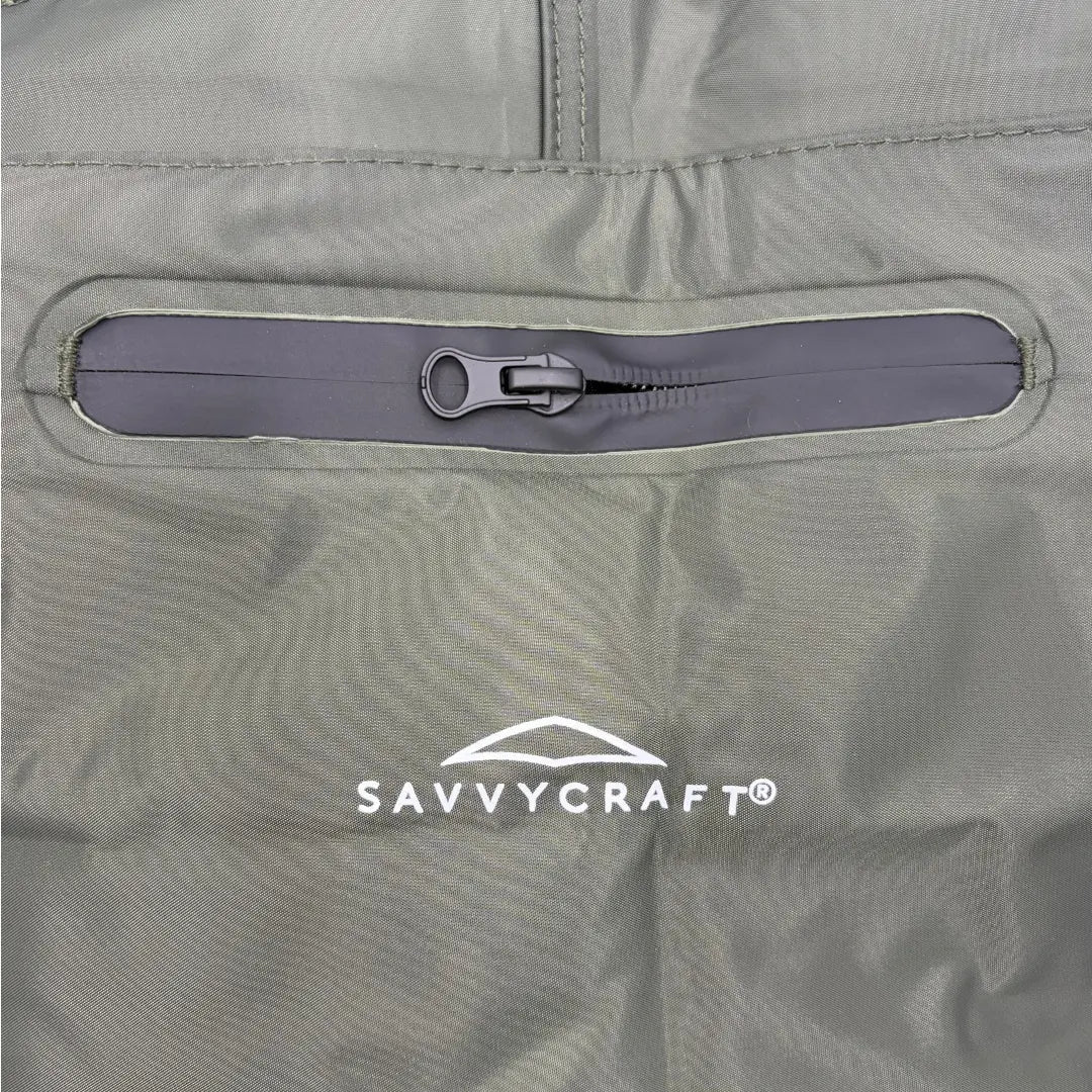 Close-up view of the front chest area of SavvyCraft green waterproof waders, highlighting the weather-resistant zippered storage pocket and the white printed SavvyCraft logo below it.