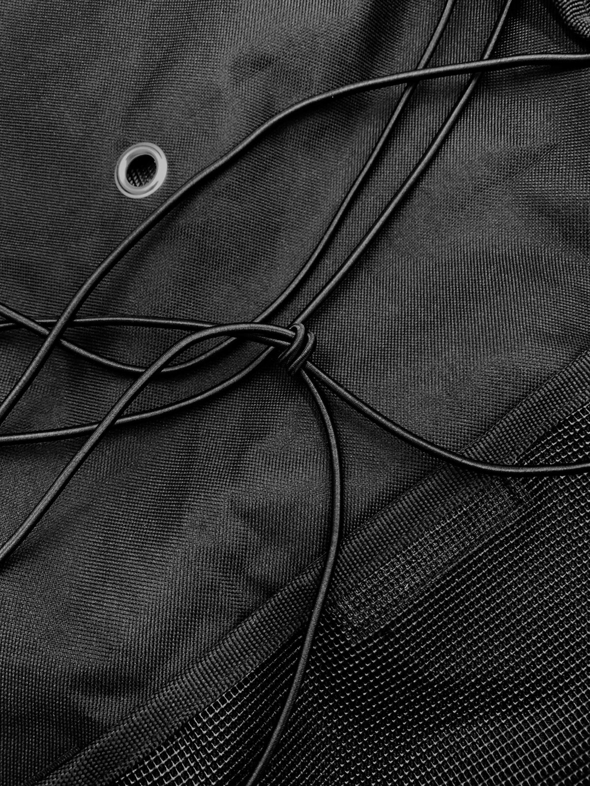 Detail of the SavvyCraft life jacket storage bag highlighting the zigzag bungee storage system and breathable mesh construction designed for marine environments