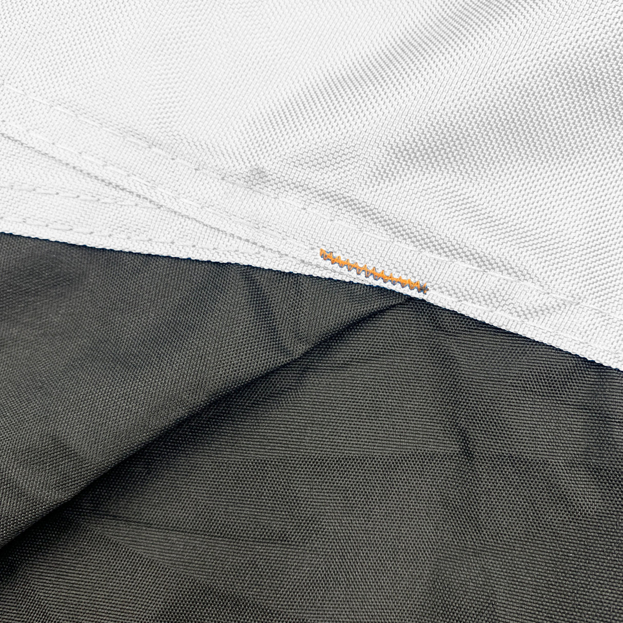 Close-up of black and white reinforced corners on a vehicle cover, designed to improve durability, prevent wear and tearing, provide extra strength for protection against abrasion, and extend cover lifespan.