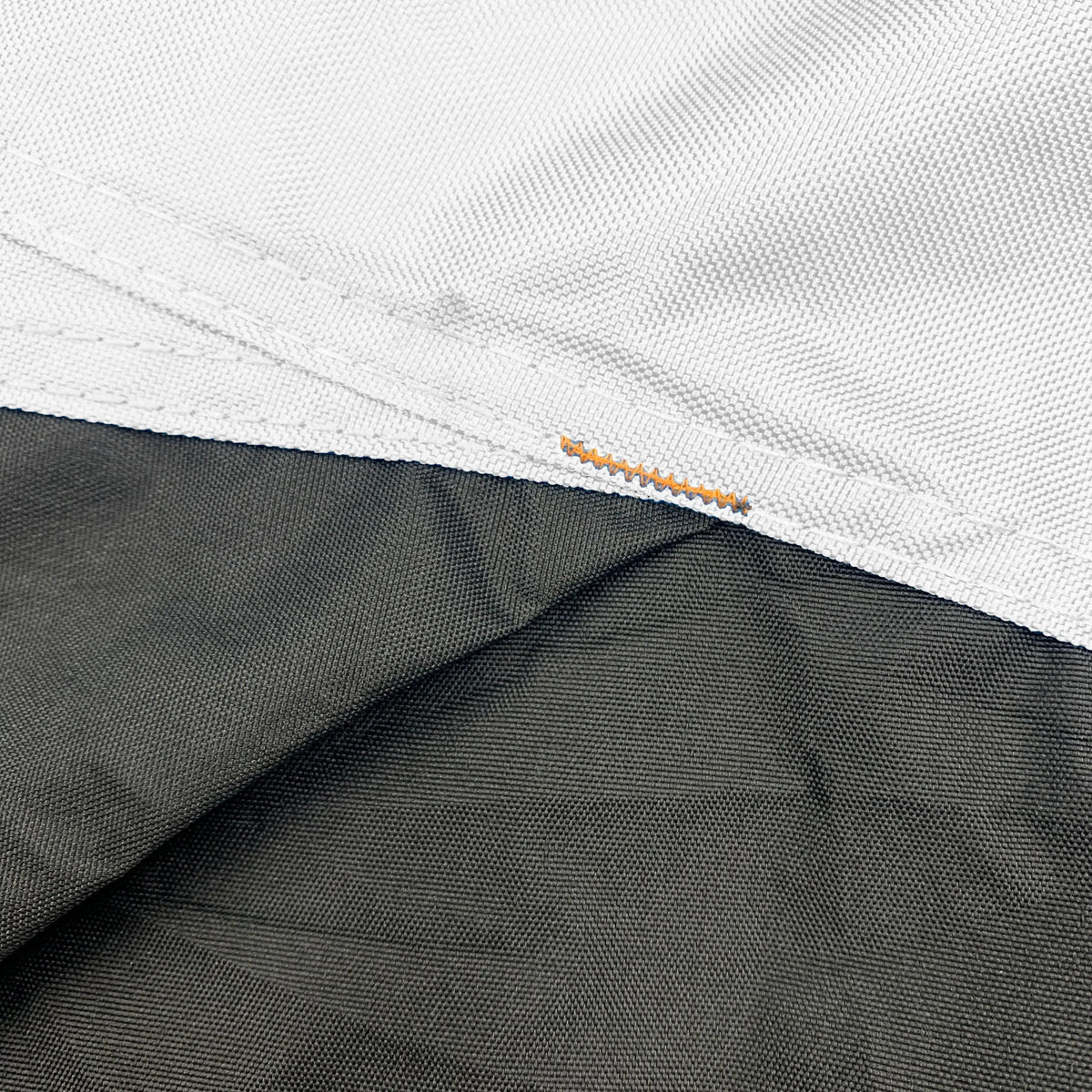 Close-up of black and white reinforced corners on a vehicle cover, designed to improve durability, prevent wear and tearing, provide extra strength for protection against abrasion, and extend cover lifespan.