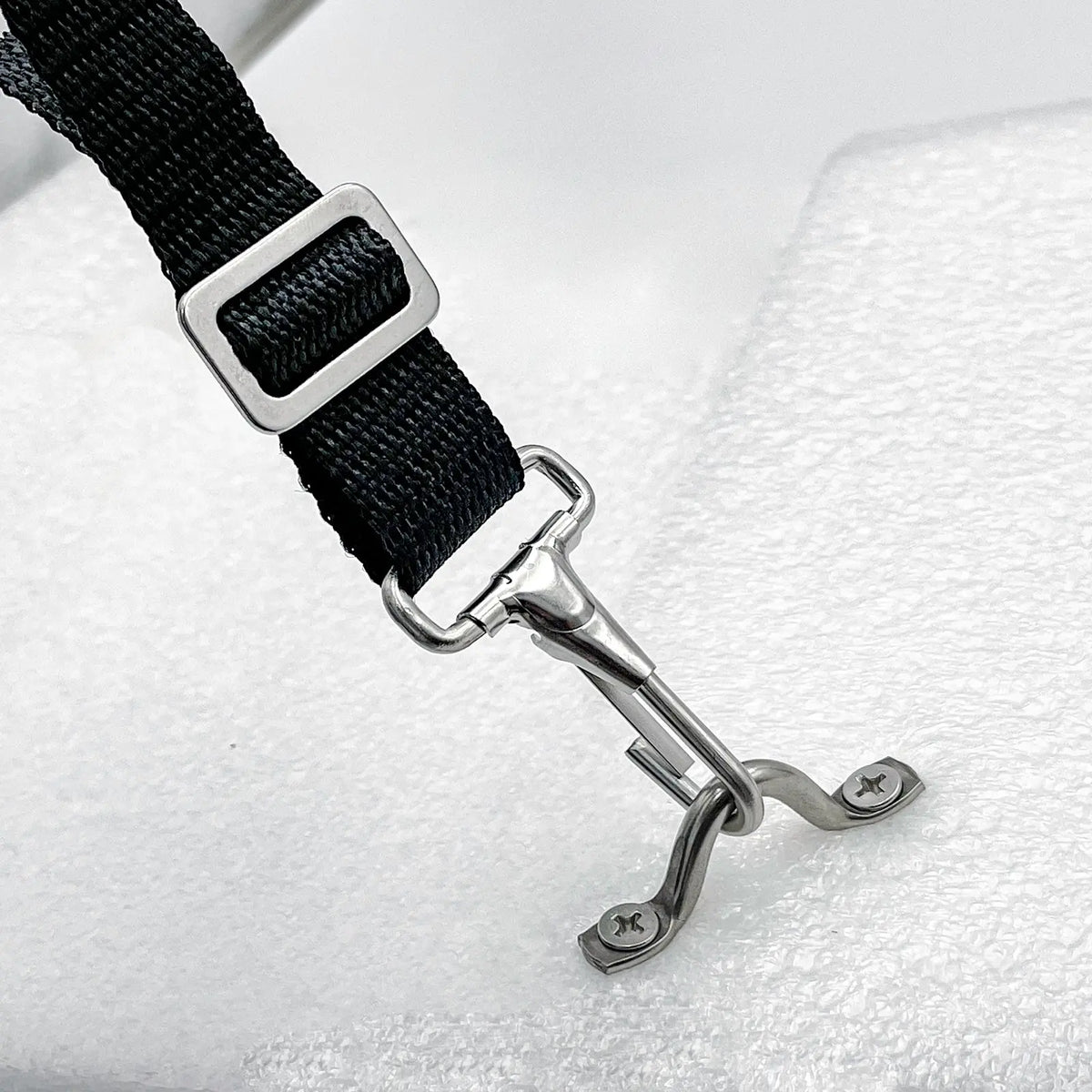 Black bimini webbing strap attached to loop snap hook on white background.