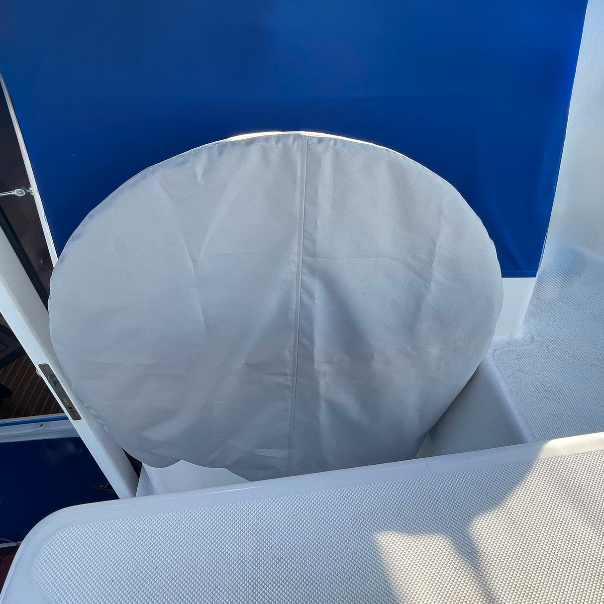 SAVVYCRAFT® grey waterproof boat steering wheel cover installed on a boat steering wheel, protecting against sun, water, and wear in a marine environment