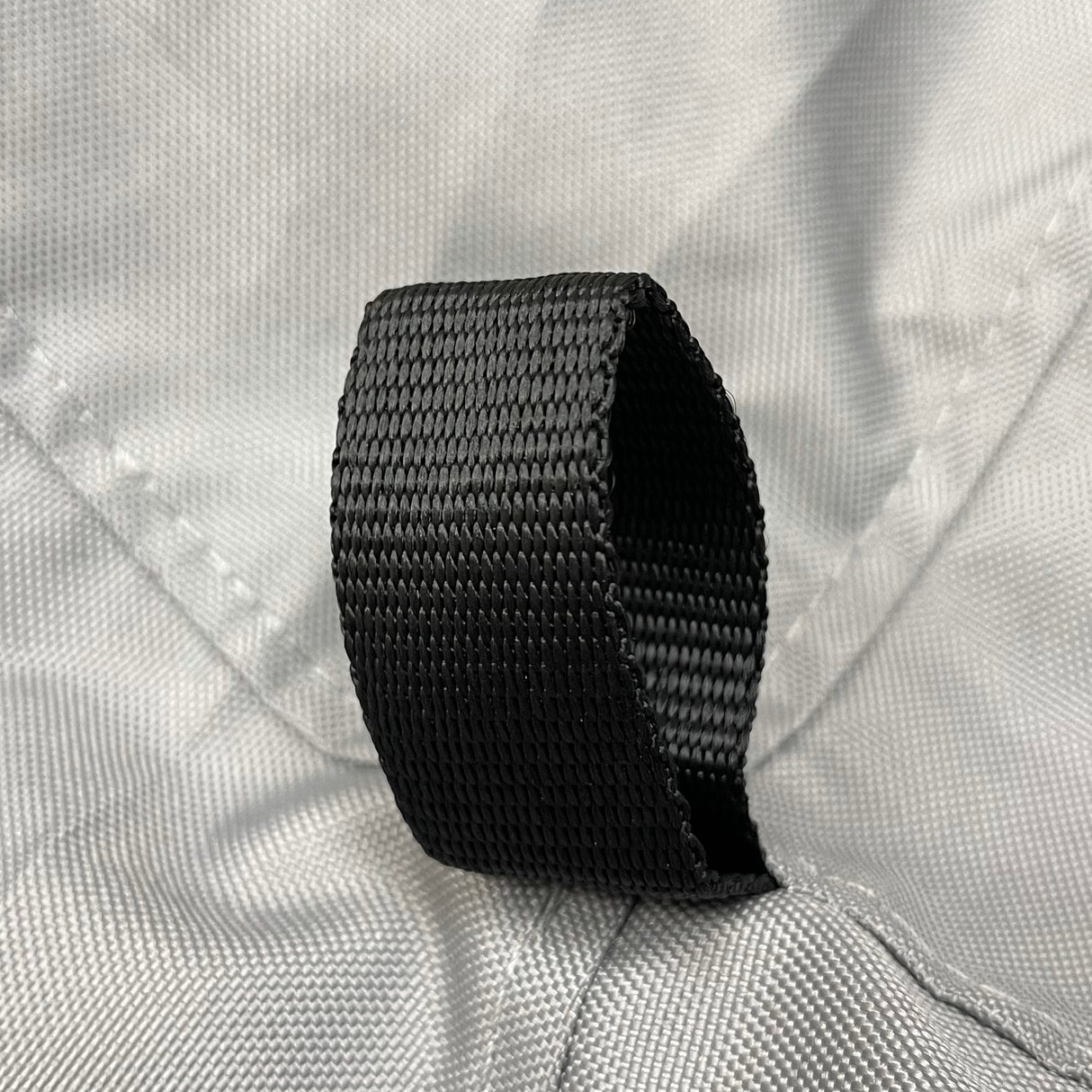 Reinforced black nylon loop securely stitched on durable grey polyester fabric, highlighting marine-grade construction and strong attachment point design on sailboat jib sail bag for secure gear handling and long-lasting outdoor performance