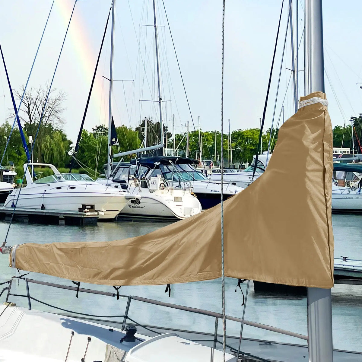 Beige waterproof mainsail boom cover installed on sailboat at marina