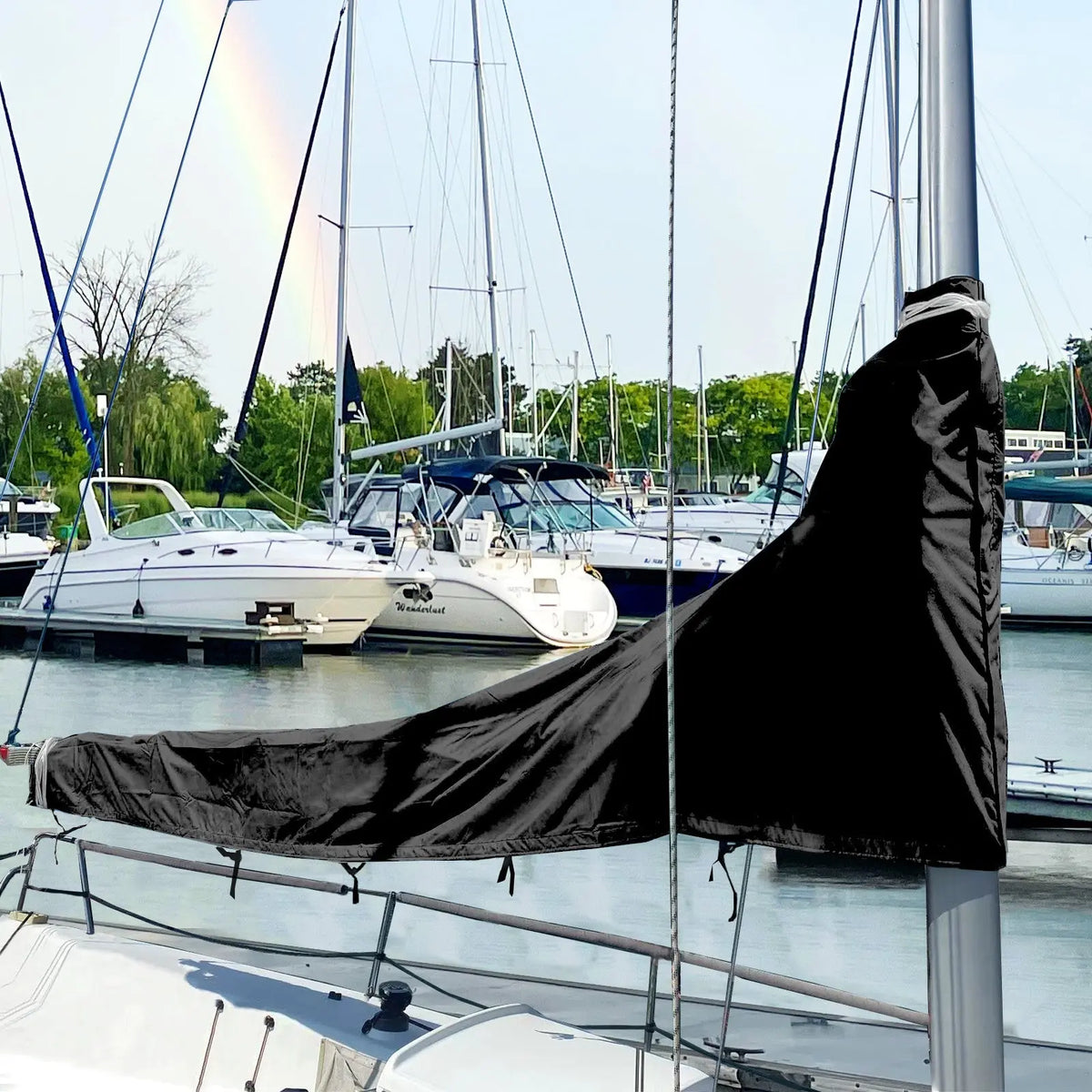 Black waterproof sailboat boom cover installed on sailboat at marina