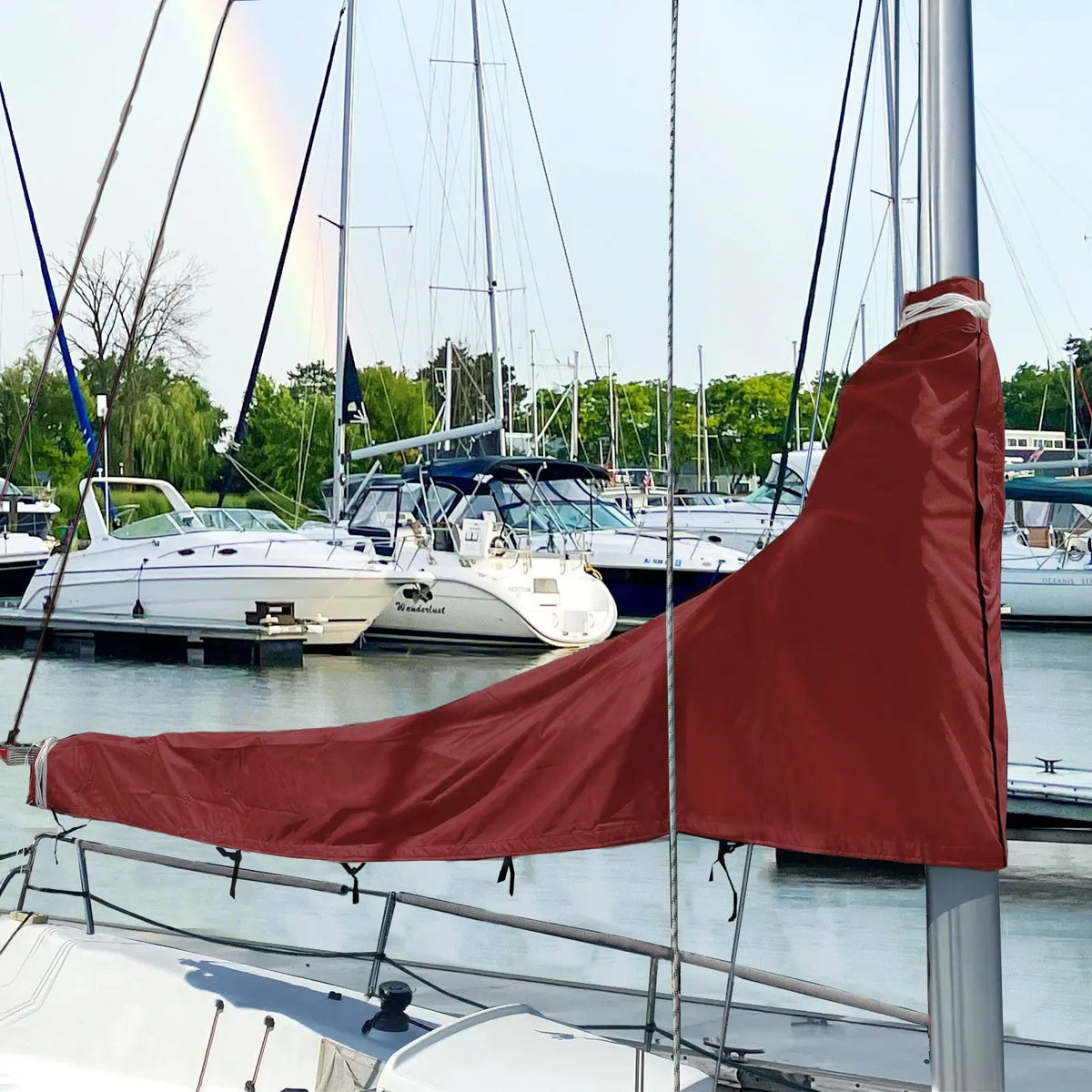 Burgundy waterproof sailboat boom cover installed on sailboat at marina