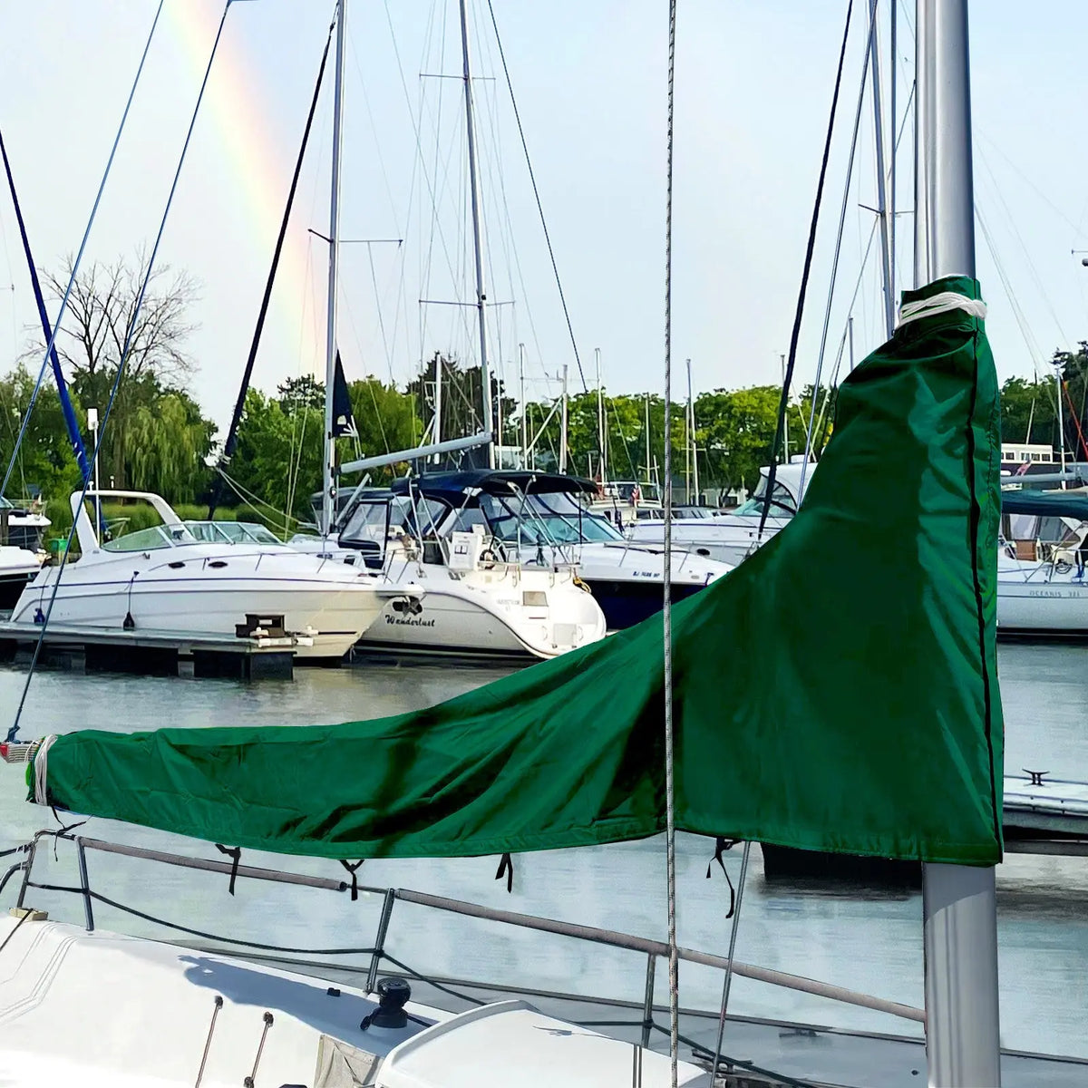 Green waterproof sailboat boom cover installed on sailboat at marina