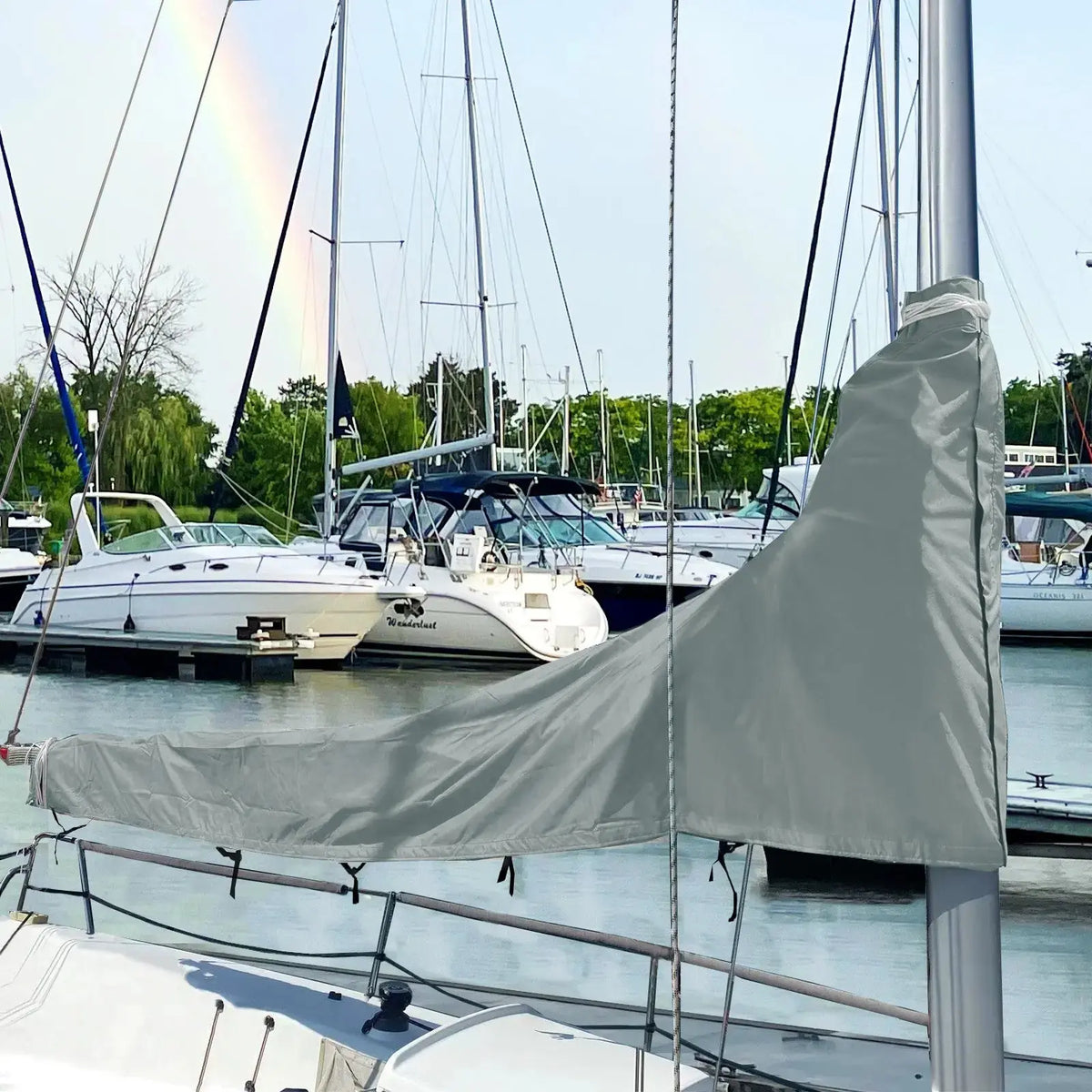 Grey waterproof sailboat boom cover installed on sailboat at marina